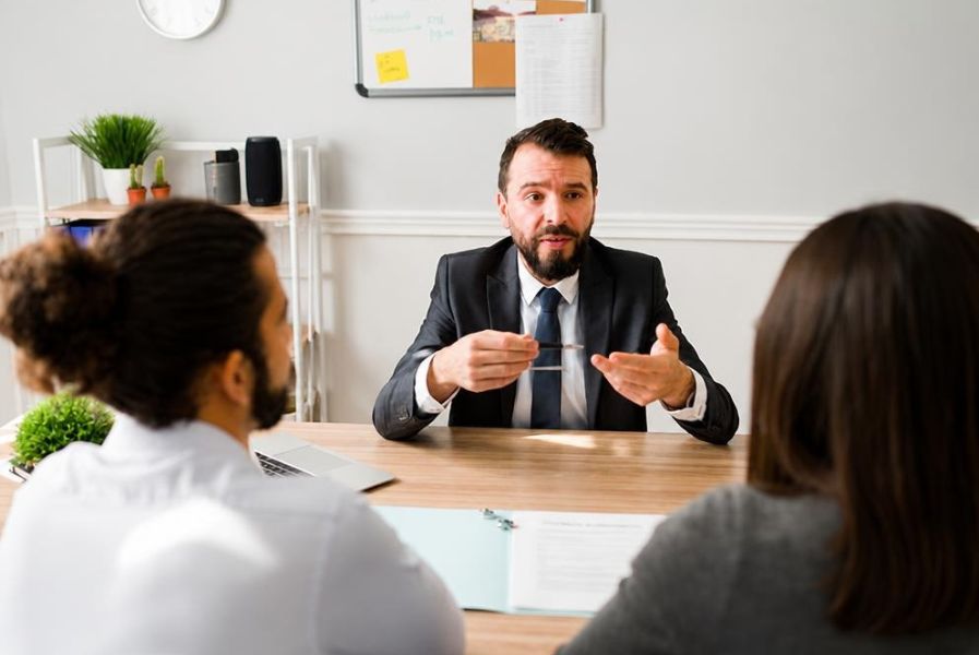 A couple discusses parenting arrangements and financial priorities with support from a neutral mediator during divorce mediation in Kansas. (1)
